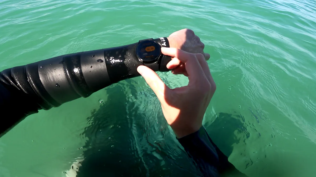 Surfer checking a message notification on their smartwatch in the water